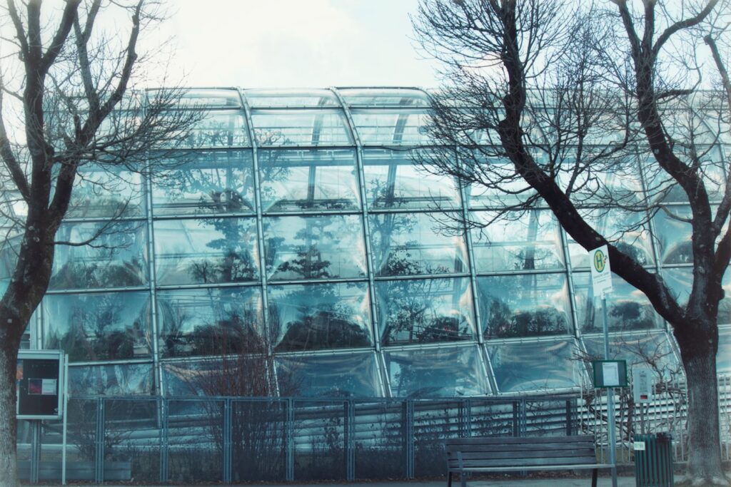Modern glass building with trees and bench